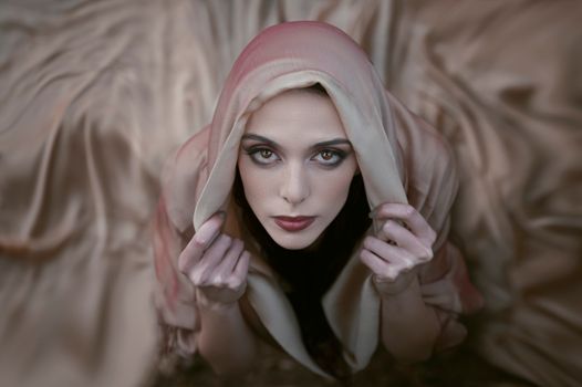 Portrait of an elegant woman in a headscarf gazing upwards with a soft focus effect.