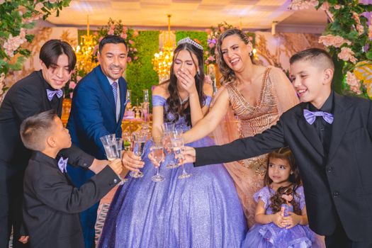 A family toasts together in a joyful quinceañera celebration, capturing a moment of happiness and togetherness.