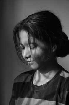 A serene black and white portrait of a young girl with a thoughtful expression.
