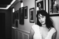 Elegant black and white portrait of a woman in a vintage-inspired hallway setting.