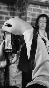 Close-up of a camera viewfinder displaying a portrait session in progress, in black and white.