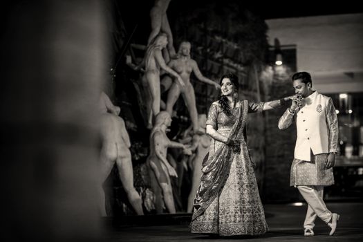 A romantic Indian couple in traditional wedding attire, capturing a timeless moment in grayscale.