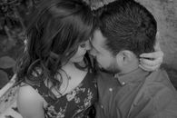 Intimate black and white photo of a couple sharing a tender moment in a natural setting.